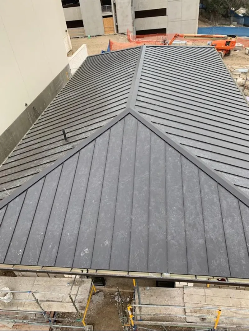 Commercial metal roof construction with crane equipment in Lyman